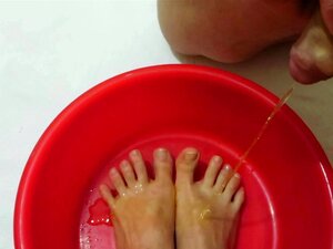 Ein Typ pisst auf die Füße einer reifen Frau