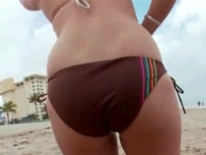 Schatje brunette speelt met haar hete kont op het strand