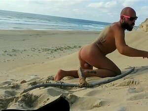 Un mec se baise sur la plage avec un gode en bois