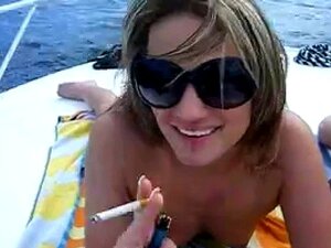 Heiße Süße Cheyenne raucht eine Zigarette auf dem Boot oben ohne