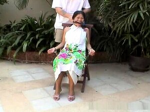 Attraktive asiatische Babe auf einem Stuhl gefesselt