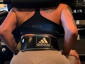 Heißes fittes Mädchen wird nach dem Fitnessstudio in der Dusche