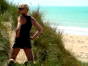 Schlanke blonde MILF gibt einen wunderbaren Handjob am Strand
