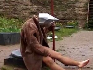 Mittelalterlicher Sklave wird draußen von drei Femdom gekickt und