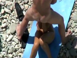 Ein Voyeur filmt Swinger, die einen Dreier an einem FKK-Strand haben