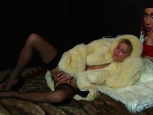 Milf in Pelzjacke mit Dildo auf Pelzbett